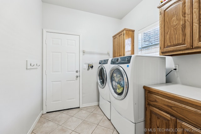 laundry room featuring cabinets, light tile patterned flooring, and separate washer and dryer