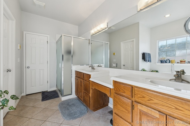 bathroom featuring tile patterned flooring, vanity, and a shower with shower door