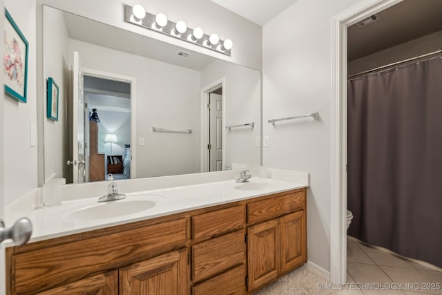 bathroom featuring tile patterned floors, vanity, and toilet