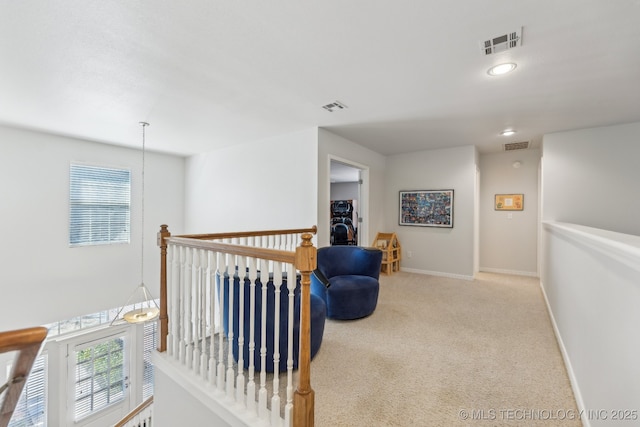 hall with a wealth of natural light and light carpet