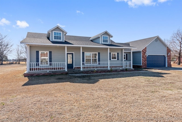 view of front of house featuring a porch, a garage, and a front yard