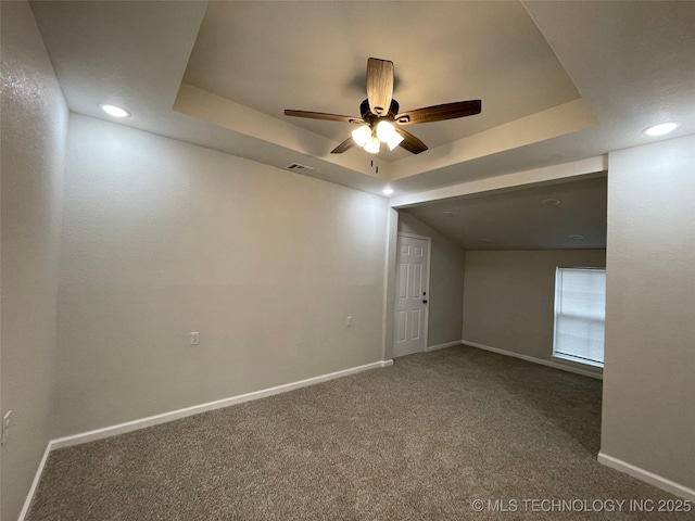 interior space featuring a raised ceiling, ceiling fan, and carpet