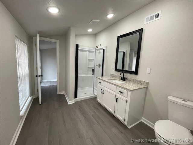 bathroom featuring walk in shower, wood-type flooring, toilet, and vanity