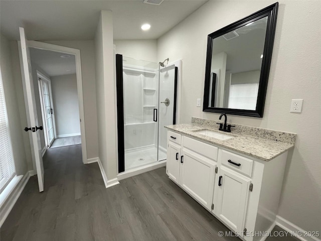 bathroom featuring vanity, a shower with door, and hardwood / wood-style floors