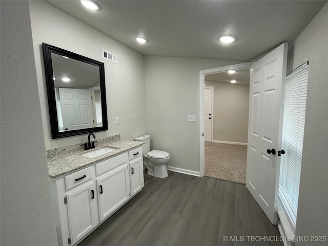 bathroom with wood-type flooring, vanity, and toilet