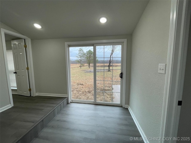 doorway featuring lofted ceiling and light hardwood / wood-style floors