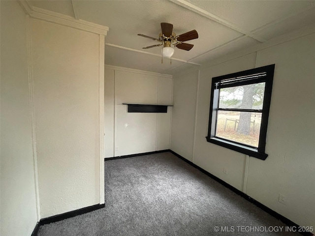 unfurnished room featuring ceiling fan and dark carpet