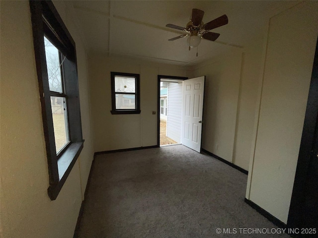 carpeted spare room featuring ceiling fan