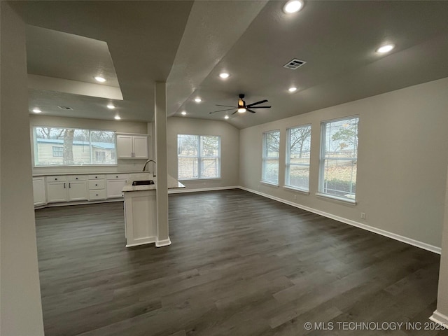 unfurnished living room with vaulted ceiling, ceiling fan, dark hardwood / wood-style flooring, and sink