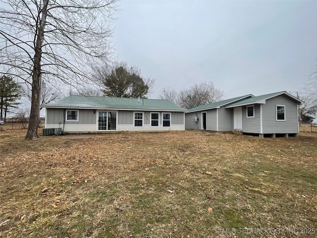 view of front of property with a front lawn and central air condition unit