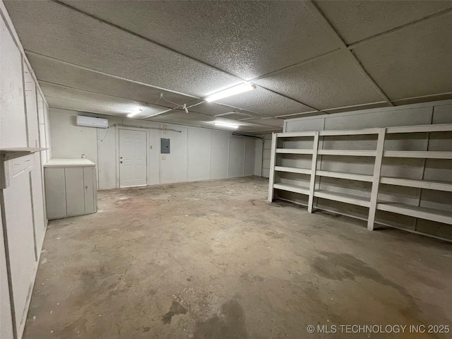 basement featuring a wall mounted AC and electric panel