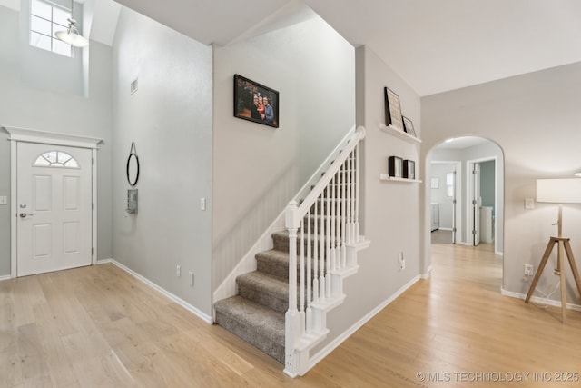 entryway featuring a high ceiling and light hardwood / wood-style floors