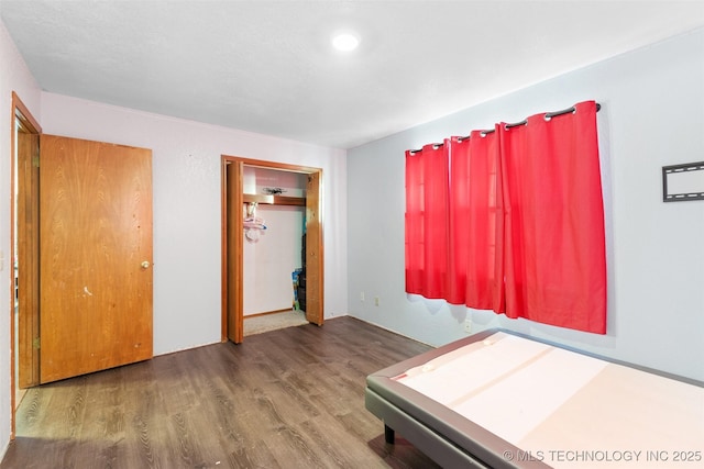 unfurnished bedroom with wood-type flooring and a closet