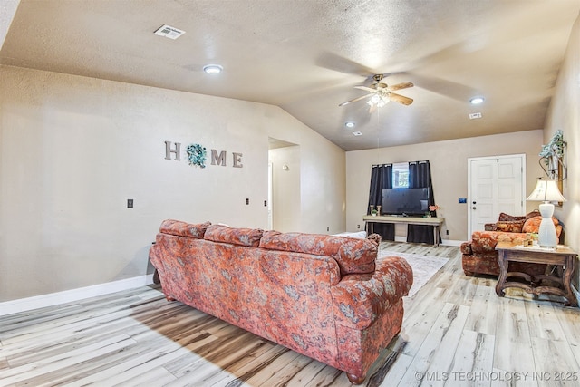 living room featuring ceiling fan, lofted ceiling, a textured ceiling, and light hardwood / wood-style floors