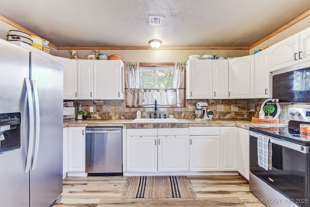 kitchen featuring white cabinetry, appliances with stainless steel finishes, sink, and decorative backsplash