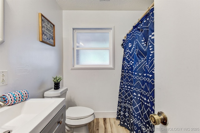 bathroom featuring vanity, hardwood / wood-style floors, a textured ceiling, and toilet