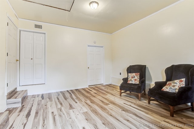 living area featuring light hardwood / wood-style flooring and ornamental molding