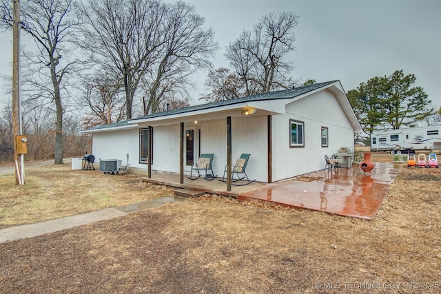 ranch-style house with cooling unit and a patio area