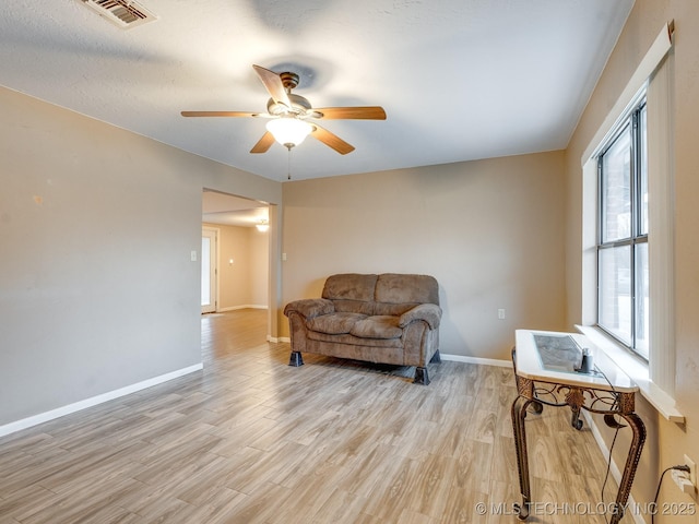 living area with light hardwood / wood-style flooring and ceiling fan