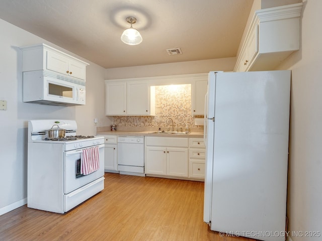 kitchen featuring sink, tasteful backsplash, white appliances, light hardwood / wood-style floors, and white cabinets