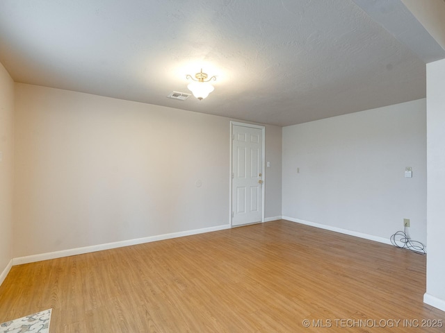 empty room featuring wood-type flooring and a textured ceiling