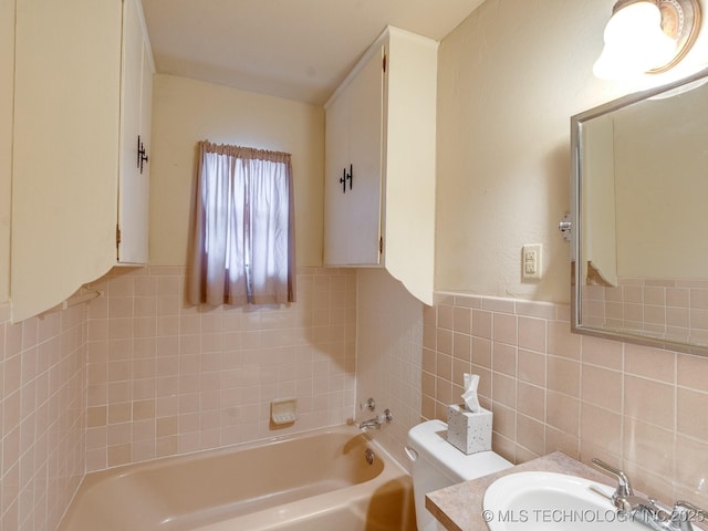 bathroom with vanity, toilet, tile walls, and a washtub