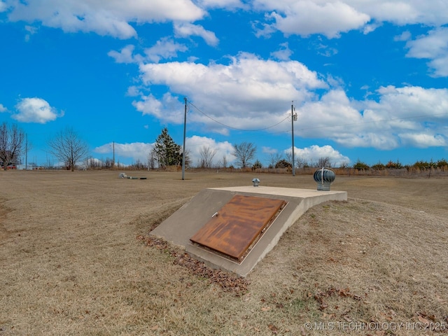 view of storm shelter with a yard and a rural view