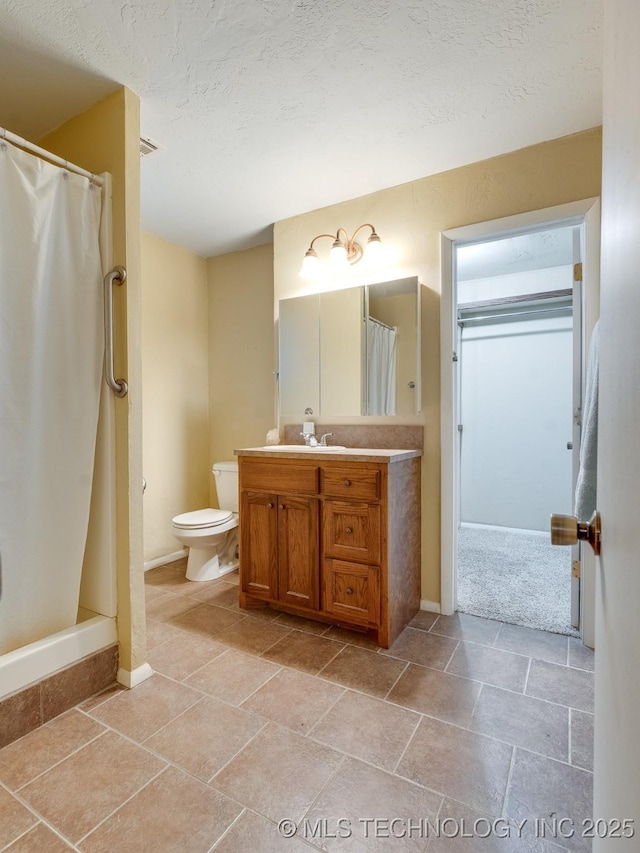 bathroom with a shower with curtain, vanity, toilet, and a textured ceiling