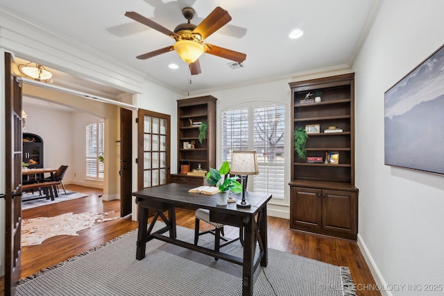 home office with dark wood-type flooring, ceiling fan, and ornamental molding