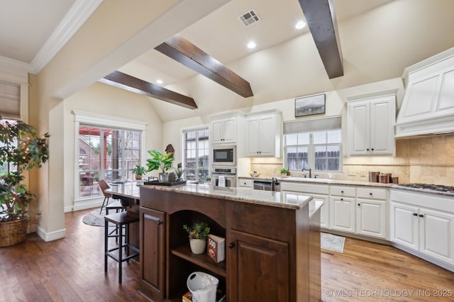 kitchen featuring stainless steel appliances, white cabinetry, and a kitchen island