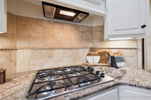 kitchen featuring white cabinetry, light stone counters, stainless steel gas cooktop, and decorative backsplash