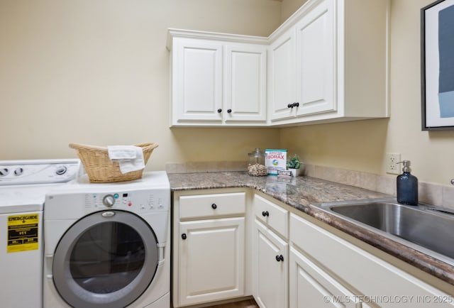 laundry room with sink, washing machine and dryer, and cabinets