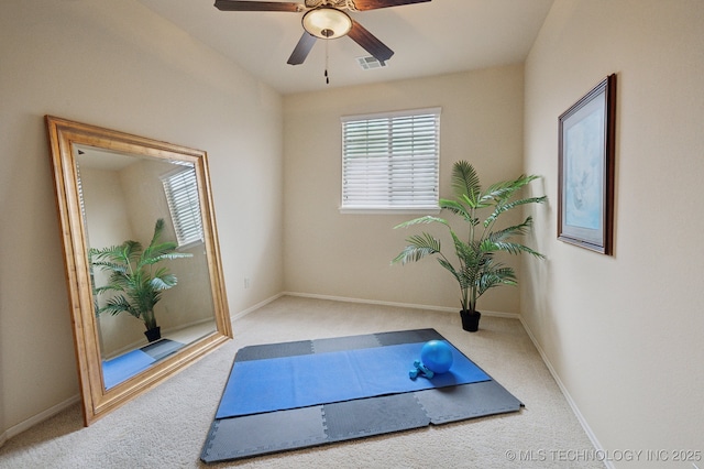 exercise room featuring light carpet and ceiling fan