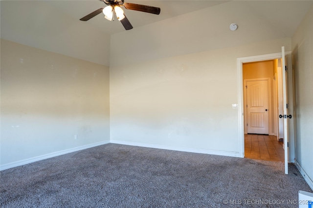 empty room featuring ceiling fan, vaulted ceiling, and carpet