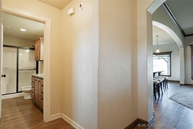 corridor with ornamental molding and dark hardwood / wood-style flooring