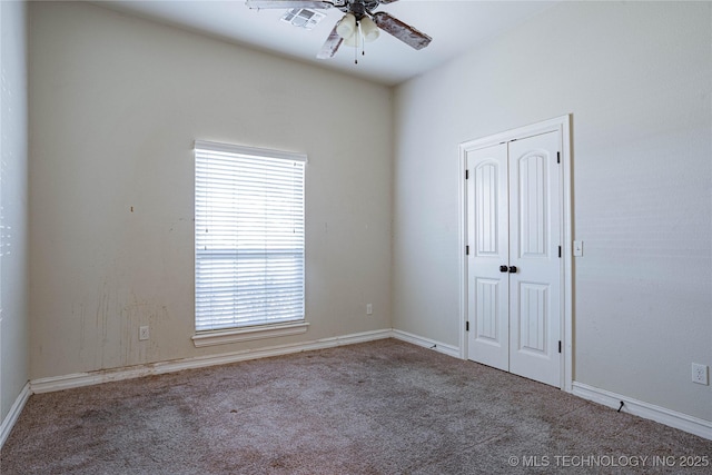 empty room with ceiling fan and carpet flooring