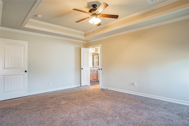 spare room featuring crown molding, a tray ceiling, carpet floors, and ceiling fan