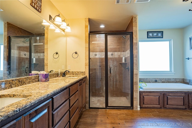 bathroom with vanity, independent shower and bath, and hardwood / wood-style floors