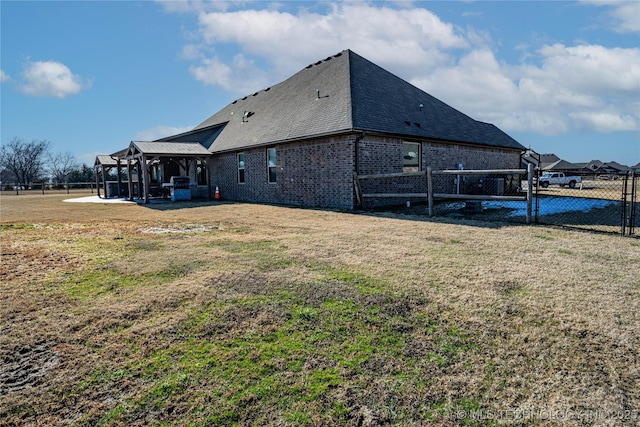 back of house featuring a patio area and a lawn