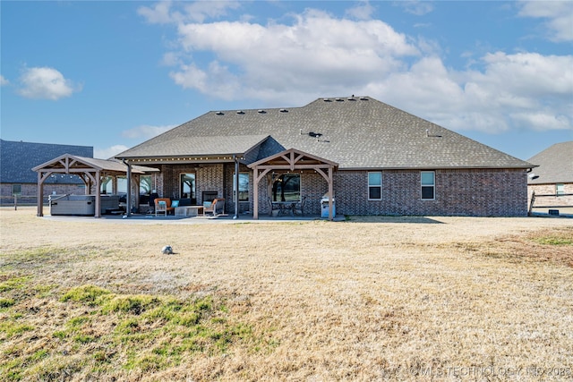 rear view of house with a patio area and a hot tub