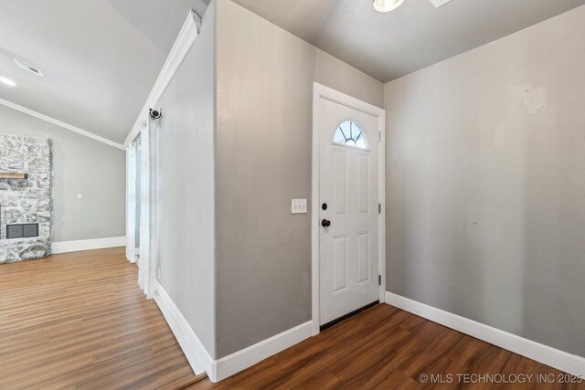 entryway with lofted ceiling, dark wood-type flooring, and a fireplace