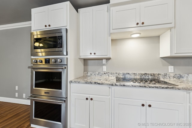 kitchen featuring white cabinetry, appliances with stainless steel finishes, dark wood-type flooring, and light stone counters