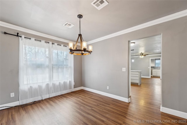 empty room with ornamental molding, ceiling fan with notable chandelier, and wood-type flooring