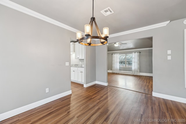 unfurnished dining area featuring crown molding, ceiling fan with notable chandelier, and dark wood-type flooring