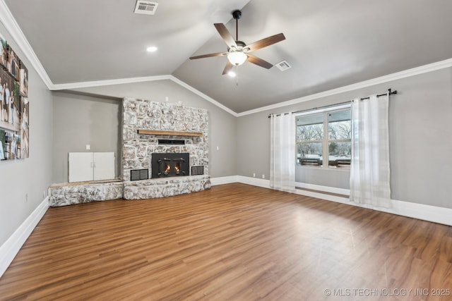 unfurnished living room featuring ornamental molding, lofted ceiling, wood-type flooring, and a stone fireplace