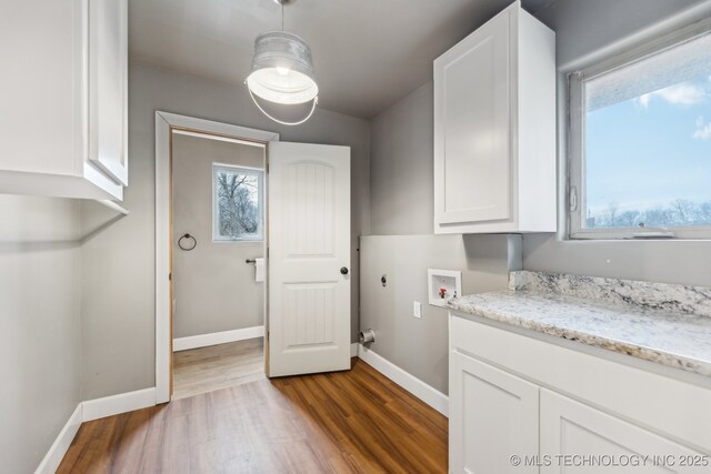 laundry area featuring hookup for a washing machine, cabinets, and light hardwood / wood-style floors