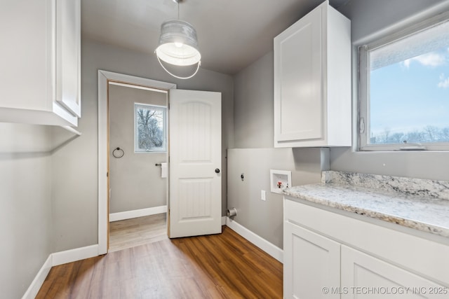 washroom featuring hardwood / wood-style floors, hookup for a washing machine, plenty of natural light, and cabinets