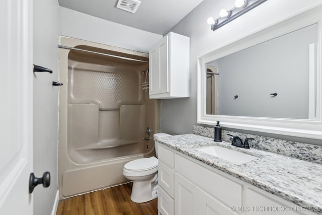 full bathroom featuring  shower combination, toilet, hardwood / wood-style floors, and vanity