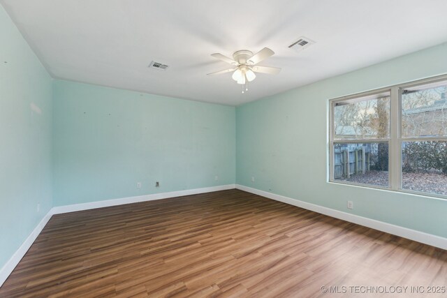 spare room with wood-type flooring, a healthy amount of sunlight, ceiling fan, and french doors