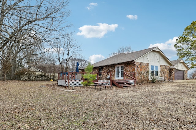 back of house featuring a wooden deck and a garage